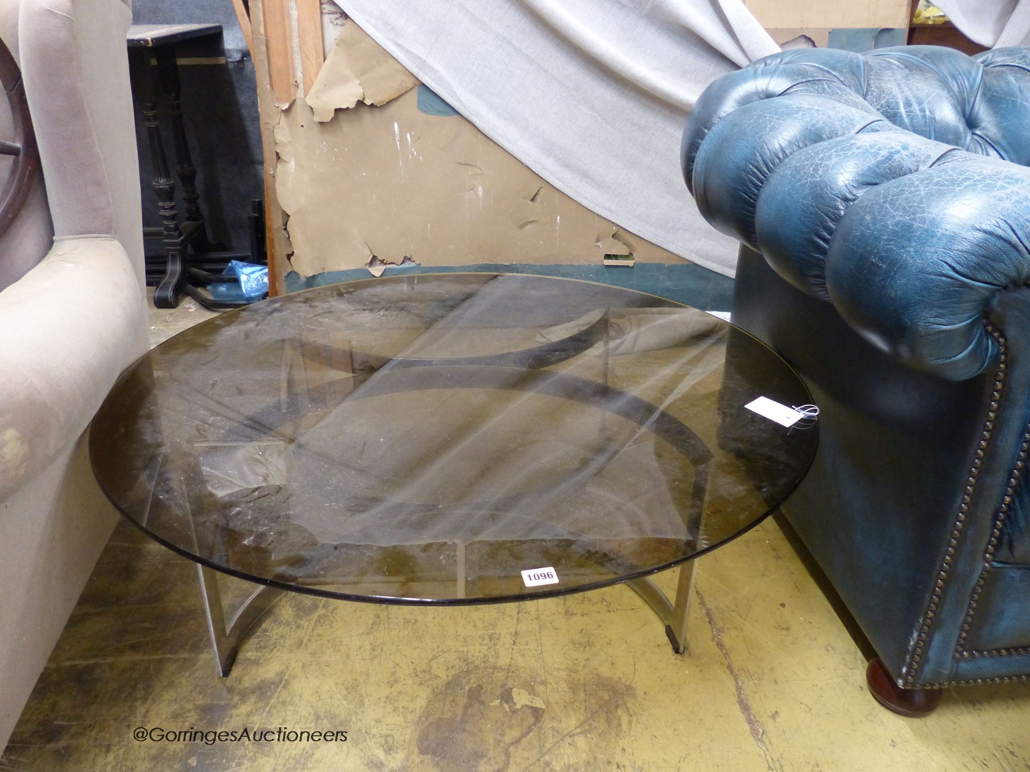 A Merrow style circular glass top table. D-100cm, H-32cm.